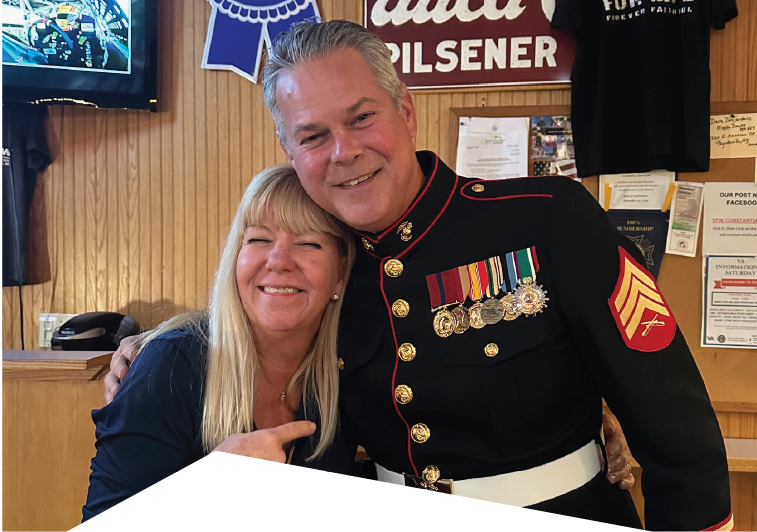 John Mura in Marine Corps uniform posing with a woman
